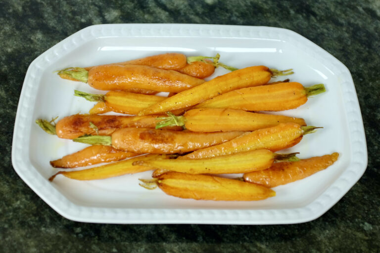 baby carrots with green top halved and fried with olive oil