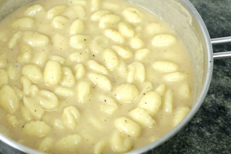 saucy gnocchi cacio e pepe with black pepper and parmesan cheese