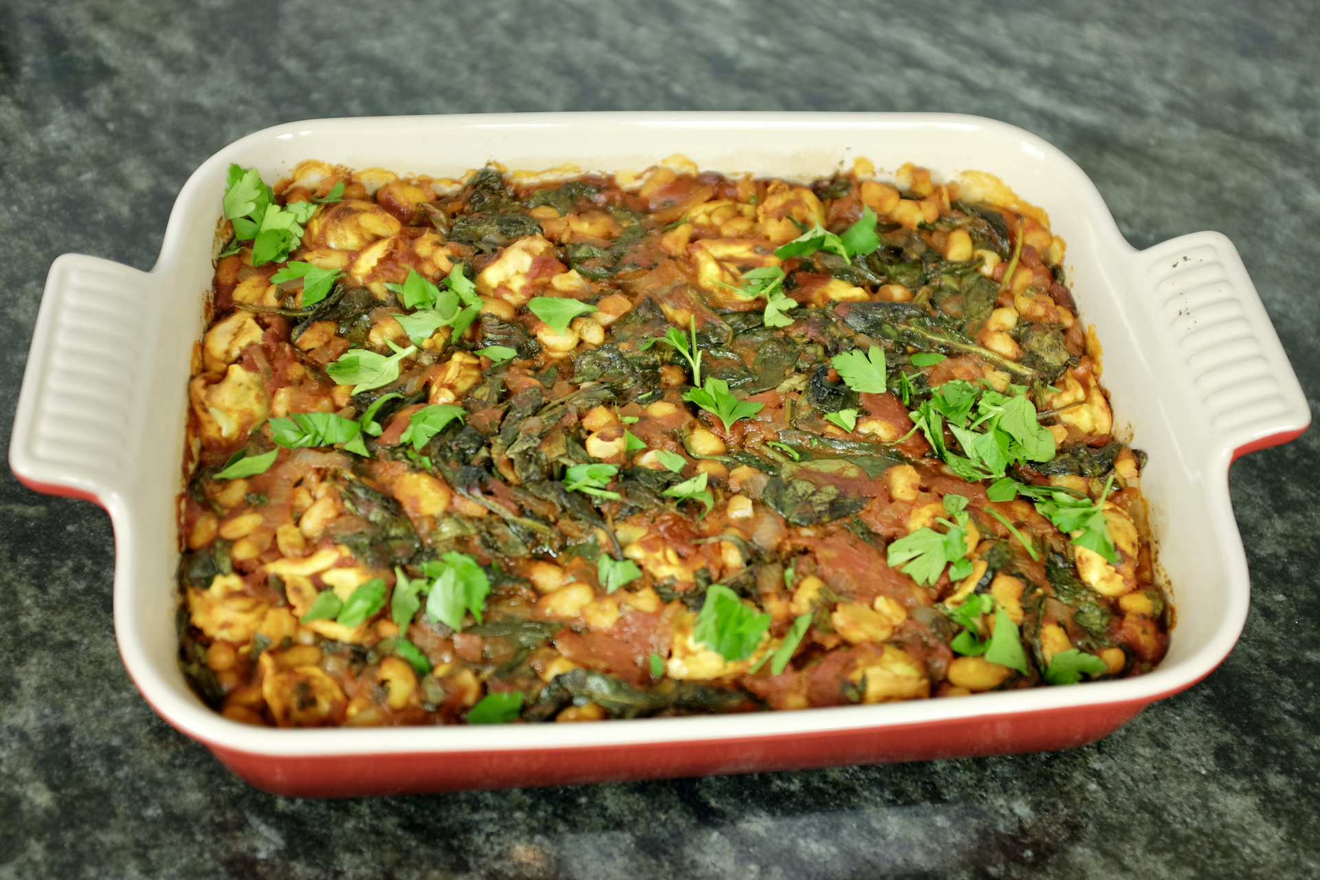 baked tortellini pasta with white kidney beans plum tomatoes spinach and fresh parsley