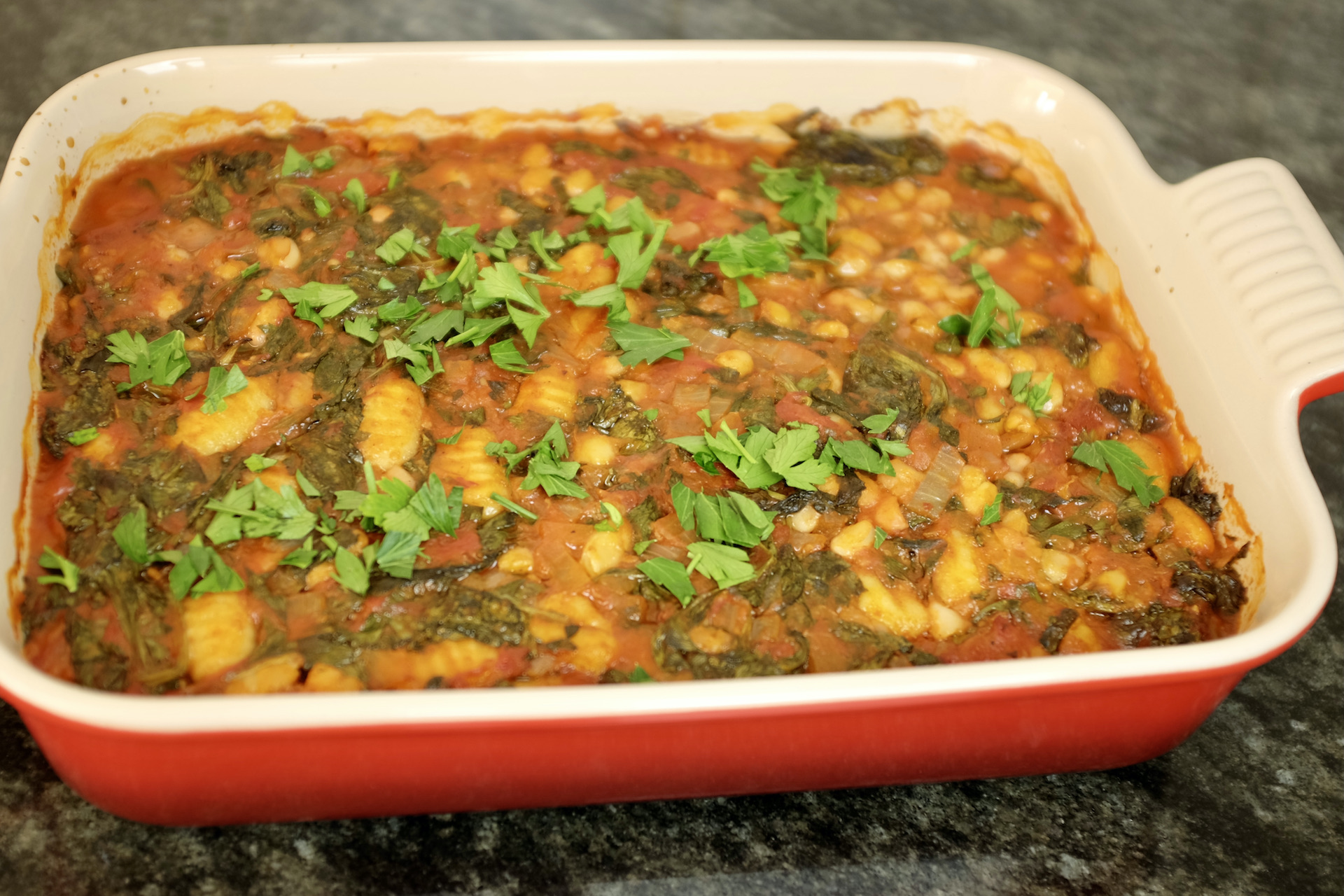 baked gnocchi with white kidney beans plum tomatoes spinach and fresh parsley