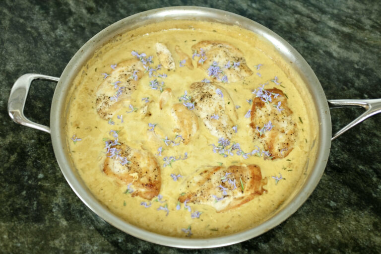 chicken breast with fresh rosemary in creamy dijon mustard sauce decorated with rosemary flowers