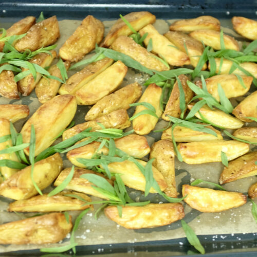 oven baked potato wedges garnished with fresh estragon on top