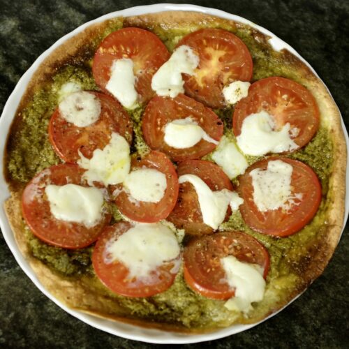 pizza style wrap with pesto verde tomato and mozzarella